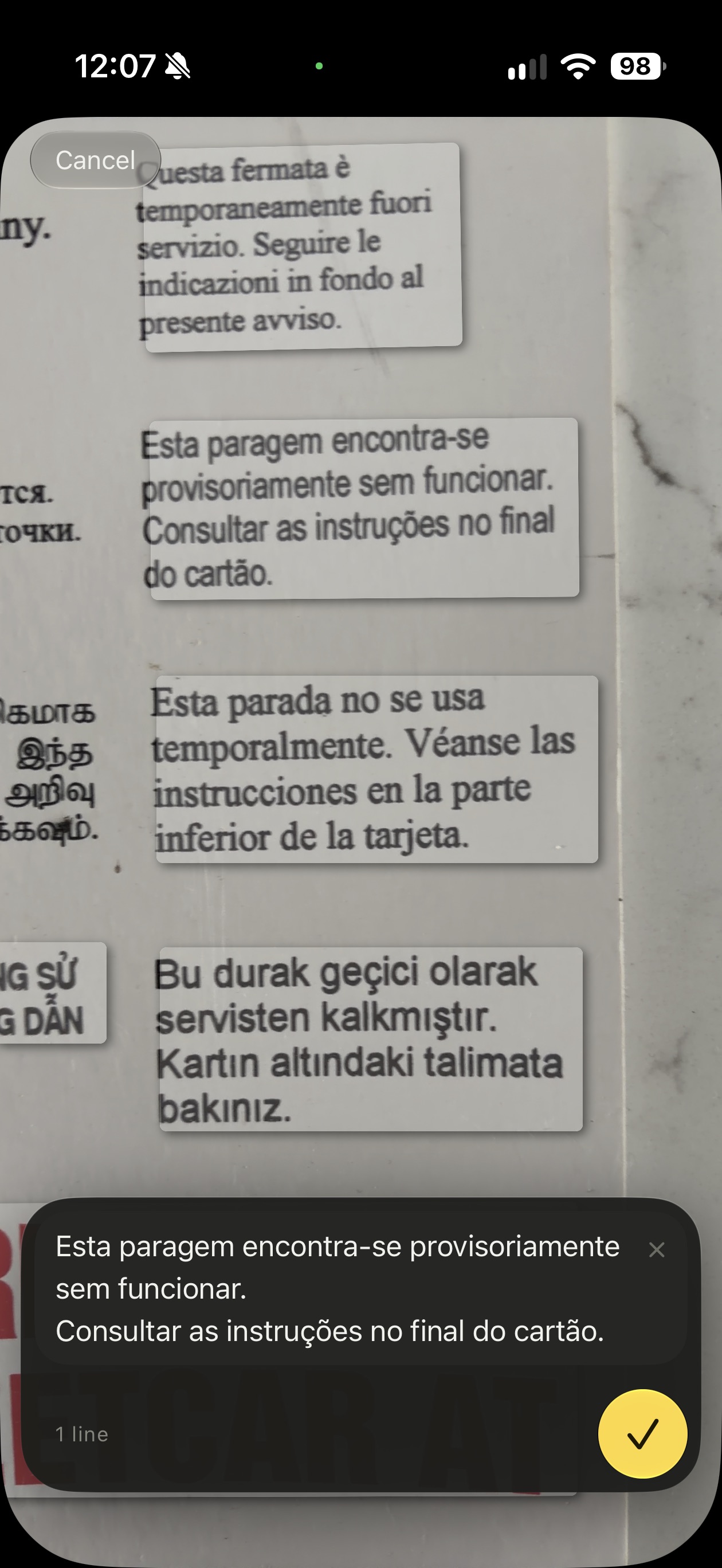 Promptly reading a multilingual notice through the camera, with the recognised Portuguese text already sitting in the writing field.